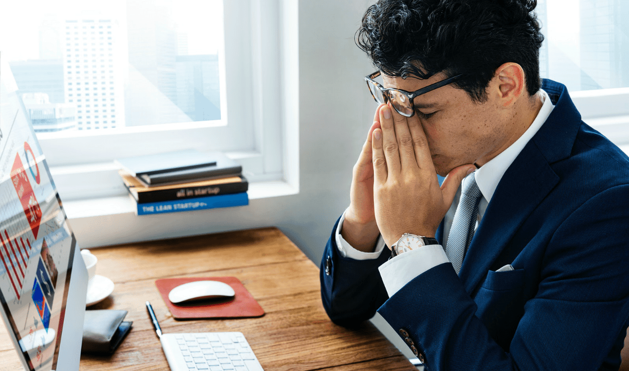 Man upset at his desk because he was fired from his job