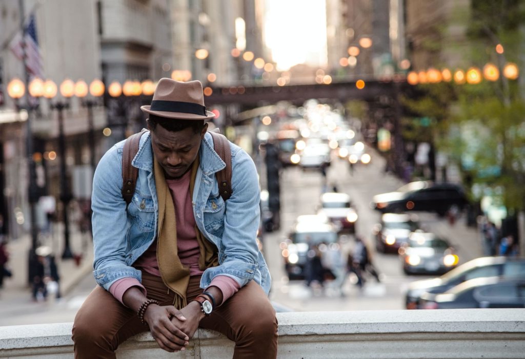 Man is frustrated and sad sitting on a bridge above a city