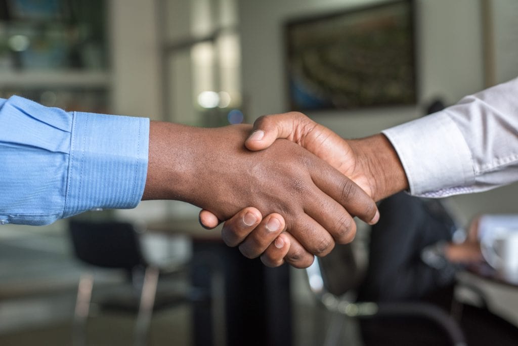 Two men shaking hands and introducing themselves to each other at an interview