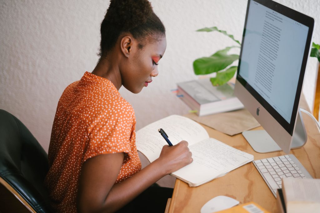 Woman sitting at her computer writing her resume